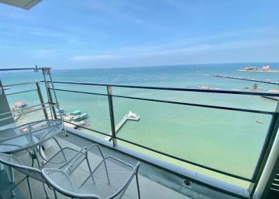 Ocean view from a high-rise balcony with seating