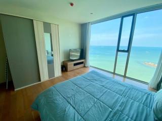Ocean view bedroom with large windows and modern furnishings
