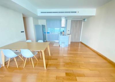 Modern dining area with wooden floors and an open kitchen layout