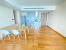 Modern dining area with wooden floors and an open kitchen layout