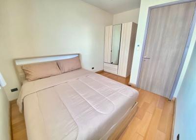 Bright bedroom with a double bed and wooden floor