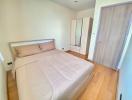 Bright bedroom with a double bed and wooden floor