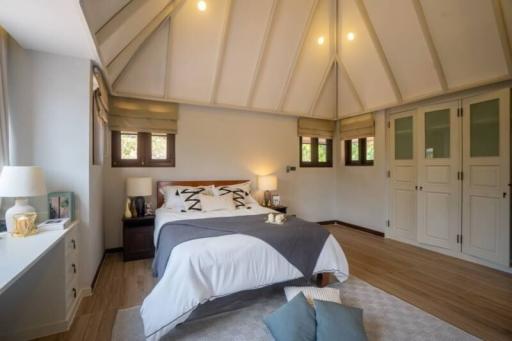 Spacious bedroom with high vaulted ceiling and hardwood floors
