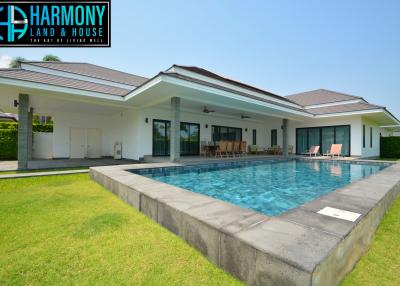 Luxurious house exterior with large swimming pool and garden