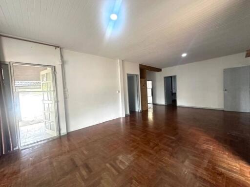 Spacious interior of a building with wooden flooring and multiple doors