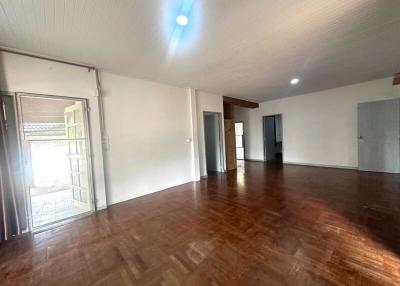 Spacious interior of a building with wooden flooring and multiple doors