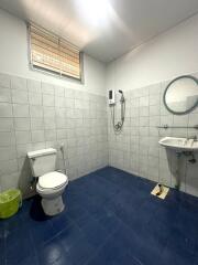 Spacious bathroom with blue tile flooring and white tiled walls