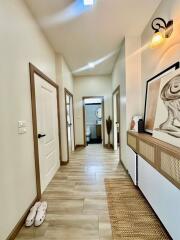 Bright and spacious hallway with wooden floors and multiple doors