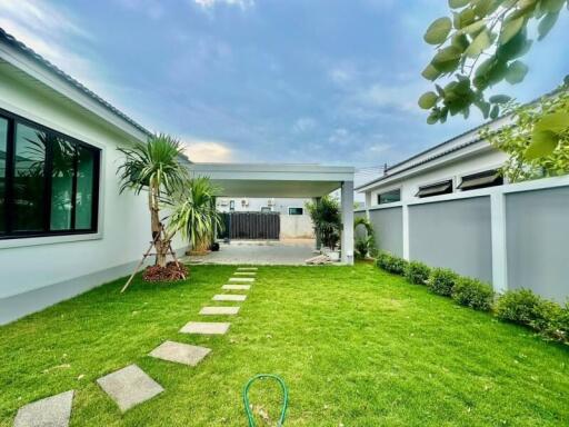 Spacious backyard with green lawn and stepping stones