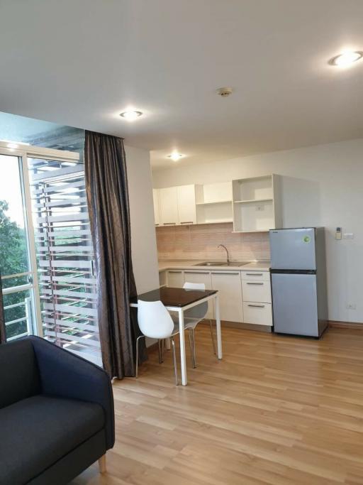 Modern kitchen with dining area, wooden floors, and plenty of natural light