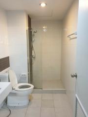 Modern white tiled bathroom with glass shower and toilet