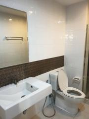 Modern white tiled bathroom with glass shower partition