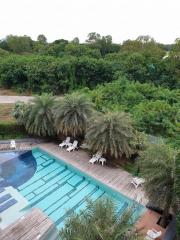 Aerial view of a pool area surrounded by lush greenery