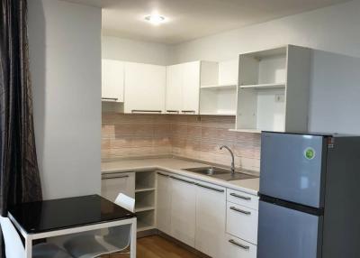 Modern kitchen with white cabinetry and wooden flooring