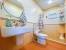 Clean tiled bathroom with sink, toilet, and accessories