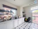 Bright kitchen with white cabinetry and geometric floor tiles