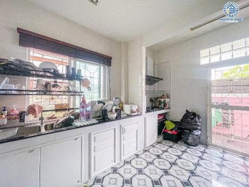 Bright kitchen with white cabinetry and geometric floor tiles