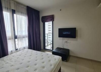 Modern bedroom with balcony access and mounted television