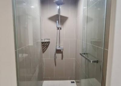 Modern bathroom with glass shower enclosure and beige tiles