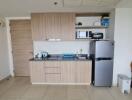 Compact modern kitchen with wooden cabinetry and essential appliances