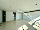 Spacious and bright unfurnished living room with large windows and glossy tiled flooring