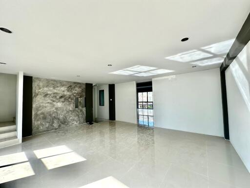 Spacious and bright empty living space with tiled flooring and natural light