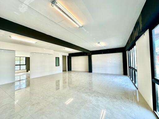 Spacious and well-lit empty interior space with large windows and glossy floor