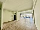 Spacious and well-lit living room with large windows and balcony access