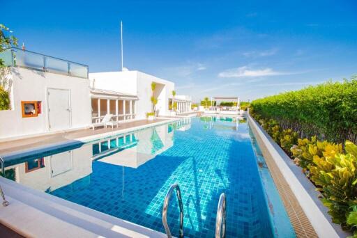Bright and luxurious outdoor pool with white building and clear blue sky