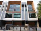 Modern multi-story residential building with balconies and wooden accents