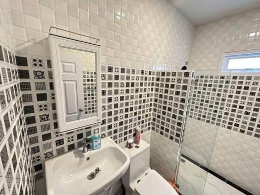 Modern tiled bathroom with sink, toilet, and shower