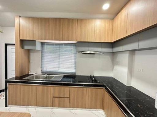 Modern kitchen with wooden cabinets and black countertop