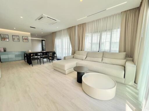 Spacious and Modern Living Room with Large Windows and Stylish Furniture