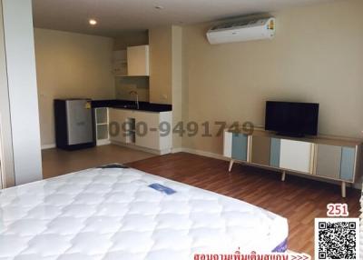 Compact studio apartment with combined living space, kitchen, and sleeping area