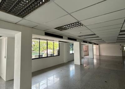 Spacious and empty commercial building interior with large windows and column structure