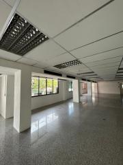 Spacious and empty commercial building interior with large windows and column structure