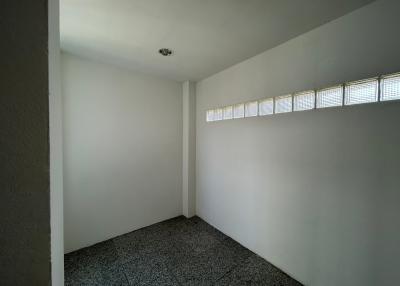 Empty interior space with high-positioned windows and terrazzo flooring