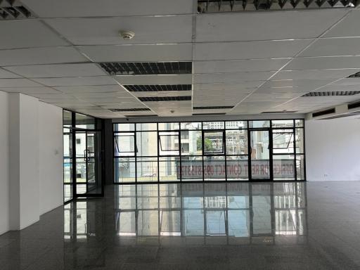 Spacious empty commercial space with large windows and city view