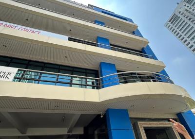 Modern multi-story building with parking space and blue accents