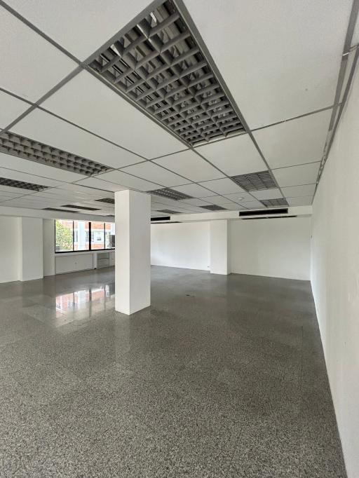 Spacious commercial space with large windows and reflective floor