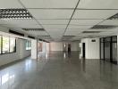 Spacious empty commercial space with reflective flooring and strip lighting