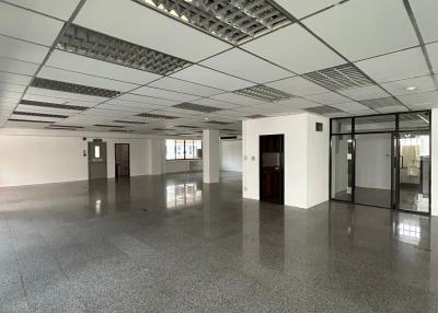 Spacious commercial office space with large windows and reflective flooring