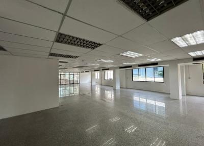 Spacious empty commercial office space with large windows and terrazzo flooring