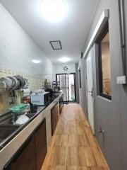 Long narrow kitchen with wooden floors and modern appliances