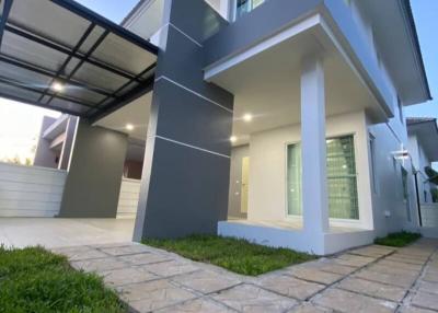 Exterior view of a modern two-story house with a carport