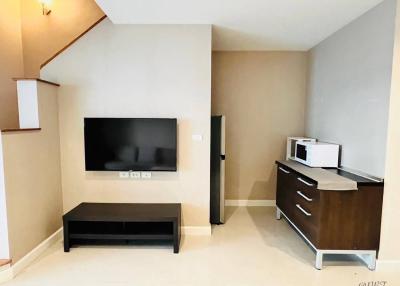 Modern living room with entertainment setup and kitchenette