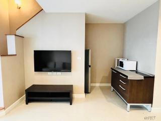 Modern living room with entertainment setup and kitchenette