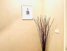 Brightly lit hallway interior with decorative twigs and framed art