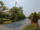 Paved street with trees and flowerbeds in a residential area under a clear sky