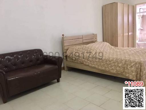 Cozy bedroom with a queen-size bed and a brown sofa